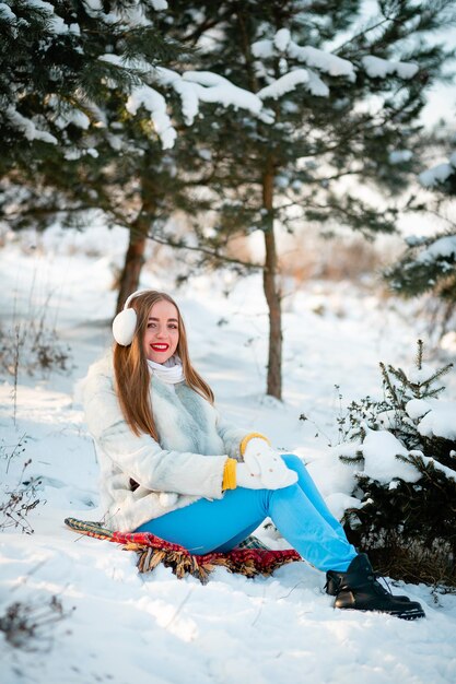 Concepción de las vacaciones de invierno Chica alegre en ropa de abrigo jugando con nieve