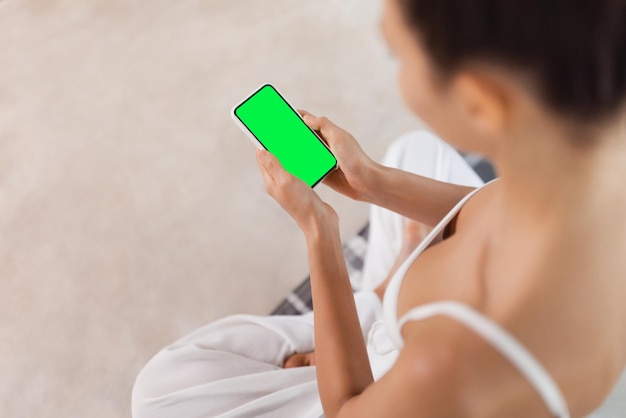 Foto concept de aplicación de meditación manos atractivas de una mujer con teléfono inteligente durante el yoga