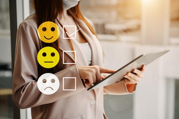Concept de evaluación de servicio al cliente mujer Mostrar cara sonrisa emoticon muestra en pantalla virtual desde handlooking en tableta y portátil