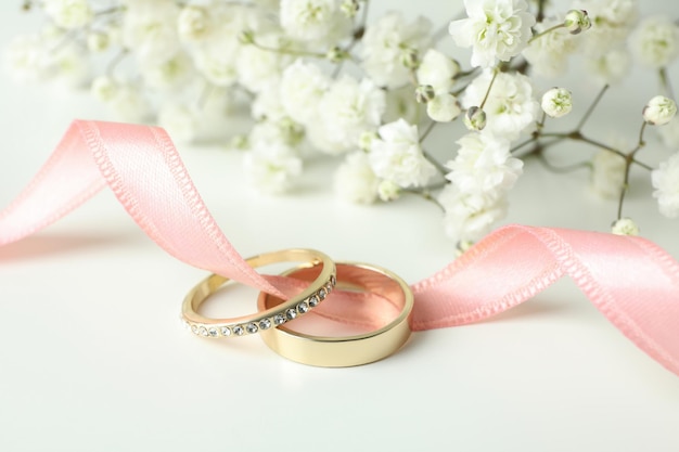 Concepto de accesorios de boda con anillos de boda sobre fondo blanco.