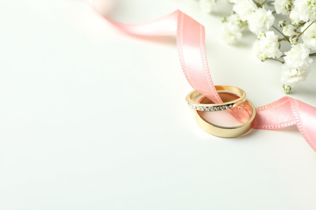 Concepto de accesorios de boda con anillos de boda sobre fondo blanco.