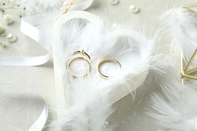 Concepto de accesorios de boda con anillos de boda sobre fondo de textura blanca