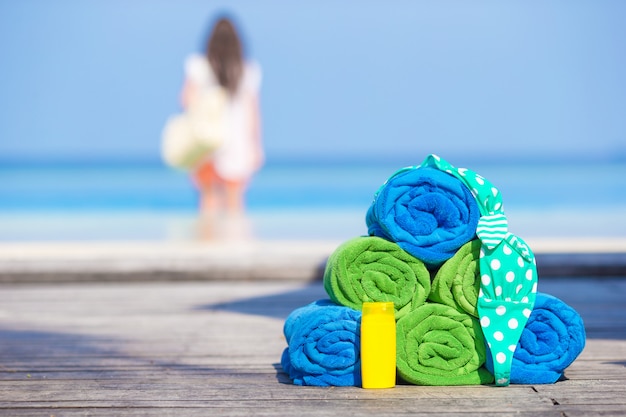 Foto concepto de accesorios de playa y verano - toallas de colores, traje de baño y bloqueador solar