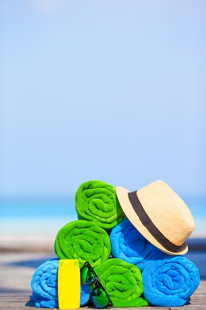 Concepto de accesorios de vacaciones de playa y verano de closeofup de toallas de colores, sombrero y protector solar