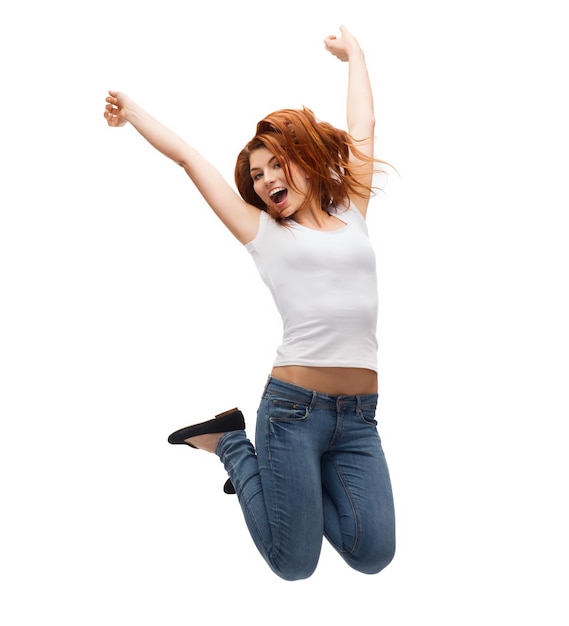 Concepto de actividad y felicidad - adolescente sonriente en camiseta blanca saltando