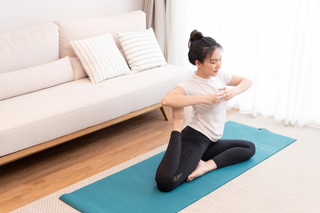 Concepto de actividad productiva una niña con un moño con la camiseta blanca haciendo el difícil movimiento de pilates.