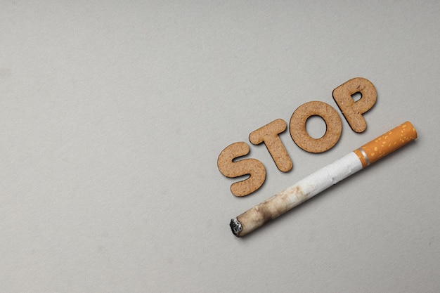 El concepto de adicción al tabaquismo palabra STOP vista superior