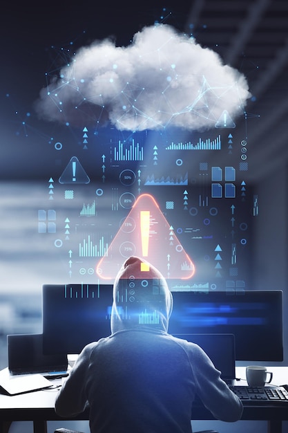 Foto concepto de advertencia y seguridad cibernética con vista posterior del hacker en hoody usando computadoras e interfaz de red de nube de datos digitales abstractos con doble exposición de signo de exclamación