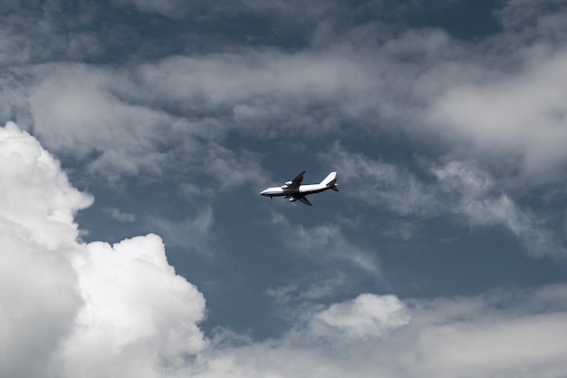 Concepto aéreo en un cielo azul entre nubes blancas y la luz del sol, un avión de pasajeros o de carga está volando