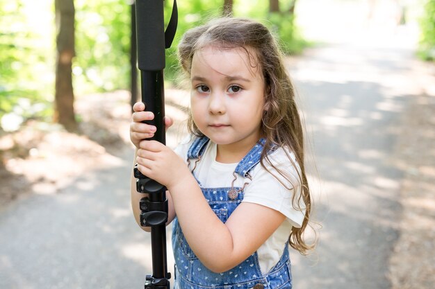 Concepto de afición, profesión, niños y fotógrafo - niño con cámara en el bosque