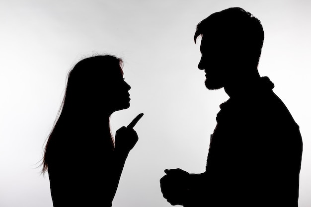 Concepto de agresión y abuso. Hombre y mujer expresando violencia doméstica en silueta de estudio
