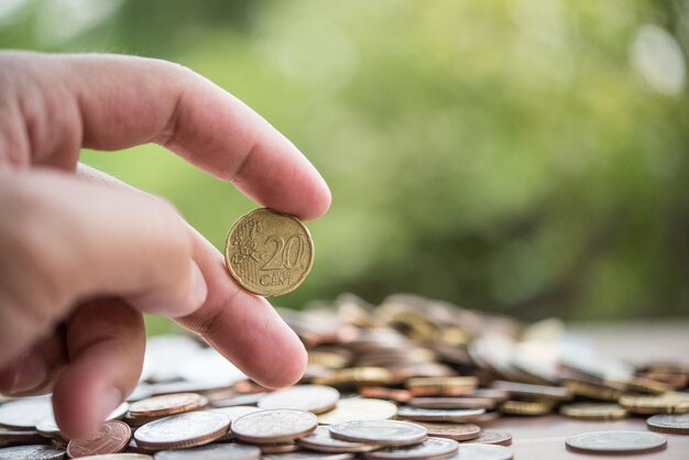 El concepto de ahorro de dinero es poner la mano en la pila de monedas.