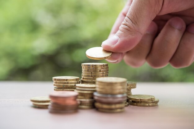 El concepto de ahorro de dinero es poner la mano en la pila de monedas.