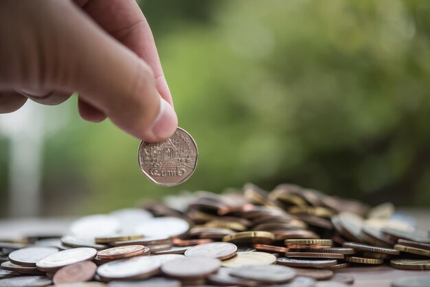 El concepto de ahorro de dinero es poner la mano en la pila de monedas.