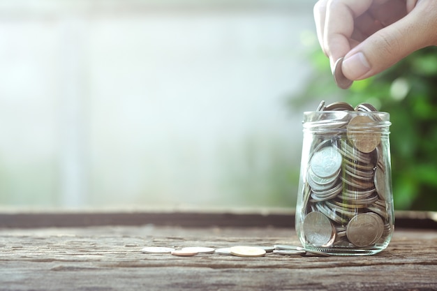 Foto concepto de ahorro de dinero con la mano poniendo el negocio de moneda de dinero