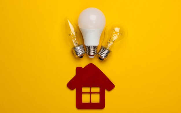 Foto concepto de ahorro de energía. figura de la casa y bombillas en amarillo.