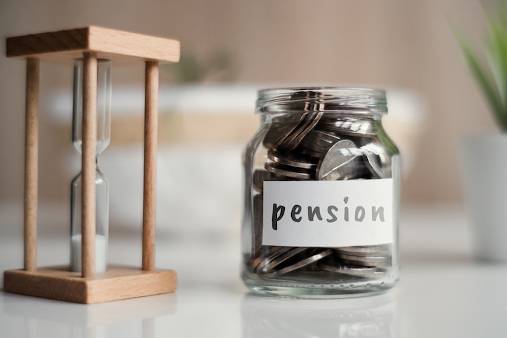 Foto concepto de ahorro de pensiones - tarro de cristal con monedas e inscripción.