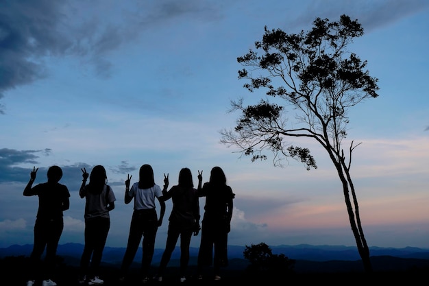 Concepto aislado Un grupo de 5 amigas viajó para aprender y encontrar nuevas experiencias en la vida Pegadas en la cima de la colina durante el atardecer