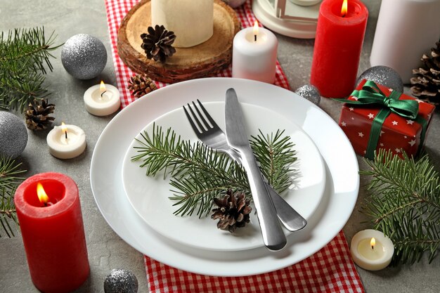 Concepto de ajuste de la tabla de año nuevo con velas en la mesa gris