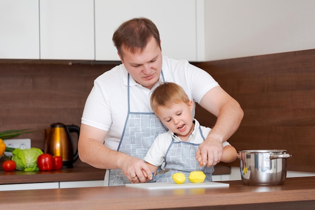 Concepto de alimentación y nutrición Foto de dos alegres padre e hijo posando en la cocina