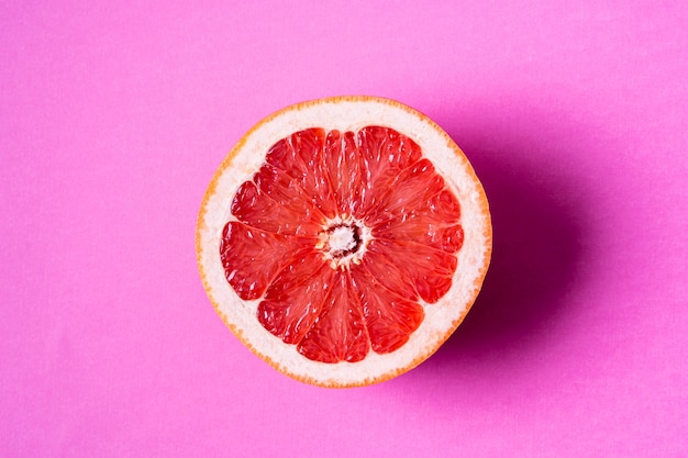 Concepto de alimentación saludable Fruta anaranjada roja fresca cruda de la opinión plana de la endecha sobre fondo rosado y espacio de la copia.