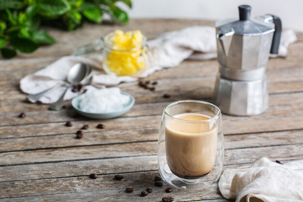 Concepto de alimentación saludable y limpia, ceto, dieta cetogénica, mesa de desayuno por la mañana. Café a prueba de balas elaborado con aceite de coco orgánico, mantequilla de ghee, granos de café. Ambiente acogedor de cafetería