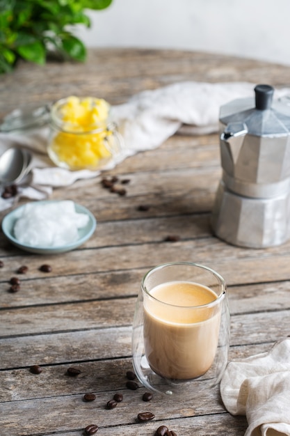 Concepto de alimentación saludable y limpia, ceto, dieta cetogénica, mesa de desayuno por la mañana. Café a prueba de balas elaborado con aceite de coco orgánico, mantequilla de ghee, granos de café. Ambiente acogedor de cafetería