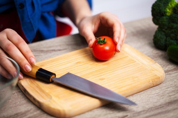 Foto concepto de alimentación saludable, mujer corta verduras frescas para ensalada