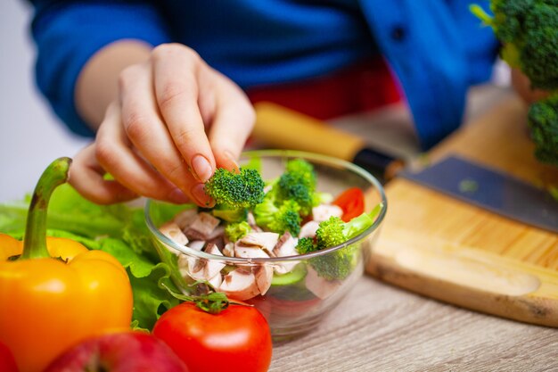 Foto concepto de alimentación saludable, mujer corta verduras frescas para ensalada