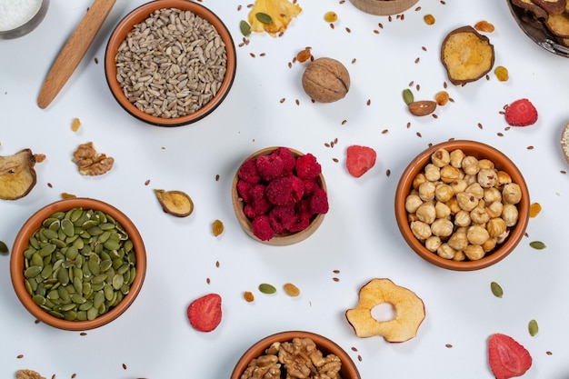 Concepto de alimentación saludable Surtido de superalimentos sobre fondo blanco Frutos secos, nueces y semillas