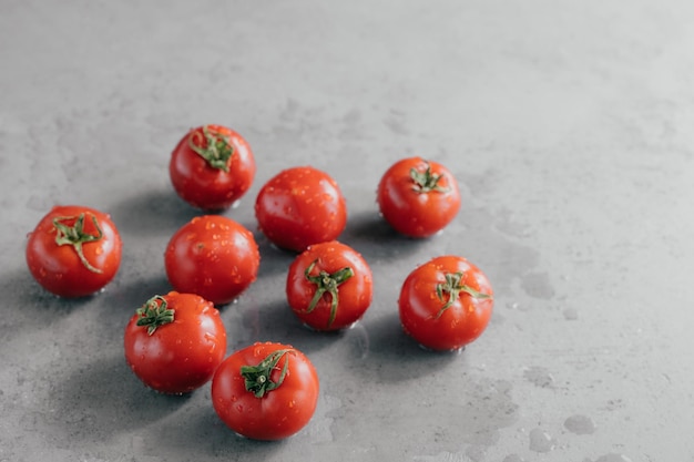 Concepto de alimentación saludable Tomates rojos frescos con gotas de lluvia para hacer una deliciosa comida vegetariana Primer plano Verduras húmedas