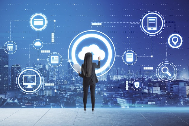 Concepto de almacenamiento de datos y tecnologías en la nube con una mujer de negocios escribiendo en una pantalla digital con iconos en la nube