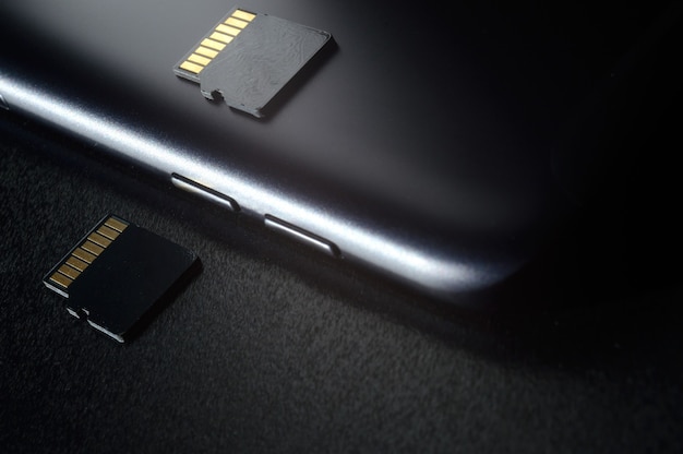 Concepto de almacenamiento de memoria flash: tarjeta Micro SD en el fondo de un teléfono inteligente. Una tarjeta de memoria se utiliza para almacenar información digital en dispositivos electrónicos portátiles como teléfonos móviles, tabletas, etc.