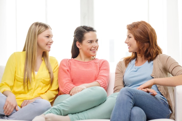 concepto de amistad y felicidad - tres amigas hablando en casa