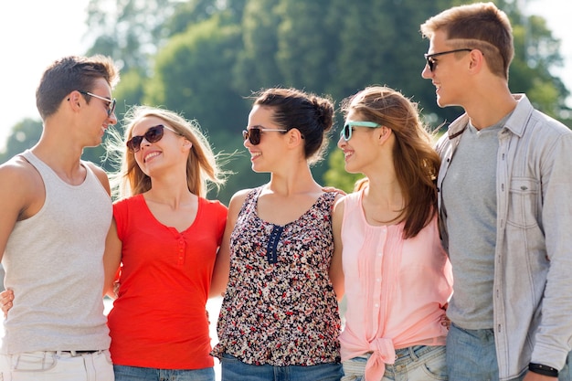 concepto de amistad, ocio, verano y personas - grupo de amigos sonrientes en la ciudad