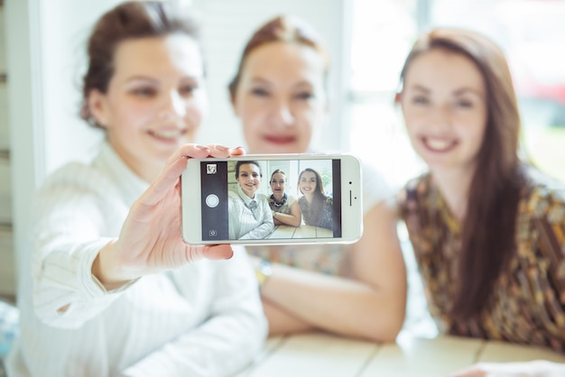 Concepto de amistad, personas y tecnología: amigos felices o adolescentes con smartphone tomando selfie