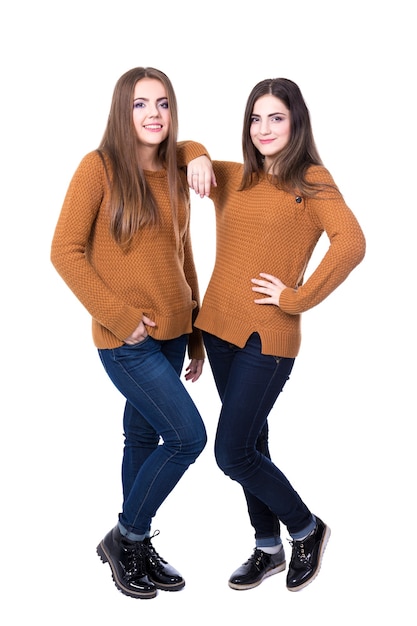 Concepto de amistad - retrato de cuerpo entero de dos niñas posando aisladas sobre fondo blanco