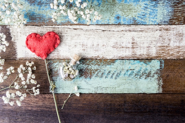 Concepto de amor de corazón de fieltro rojo y flores de gypsophila en silla vintage