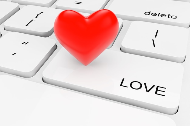 Concepto de amor. Corazón rojo extreme closeup en un teclado