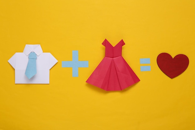 Concepto de amor Ecuación con camisa de origami para hombre vestido de mujer y corazón sobre fondo amarilloxA