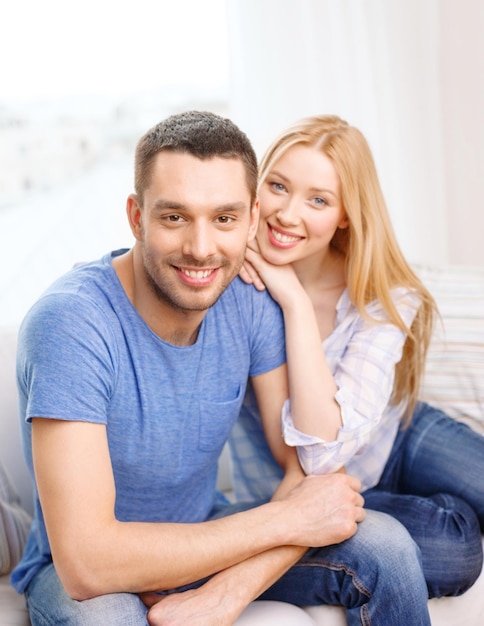 concepto de amor, familia y felicidad - pareja feliz sonriente en casa