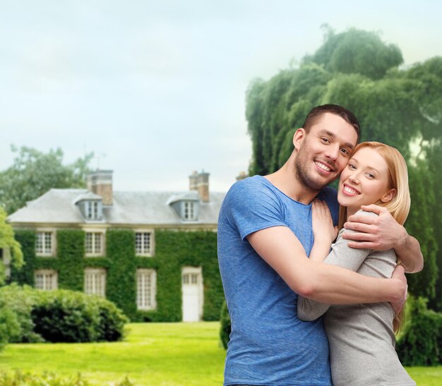 concepto de amor y familia - pareja sonriente abrazándose