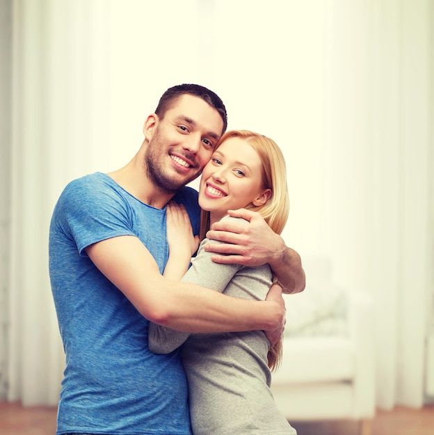 concepto de amor y familia - pareja sonriente abrazándose