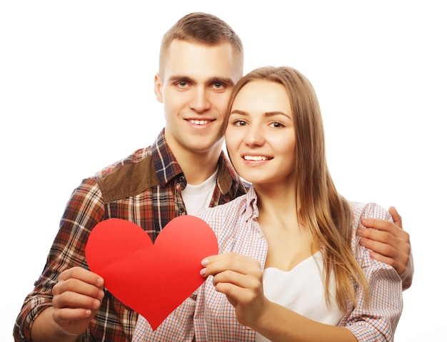 Concepto de amor, familia y personas: Pareja feliz enamorada con corazón rojo.