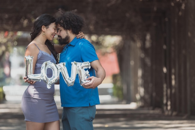 Foto concepto de amor real de pareja joven mexicana cara a cara con globo de texto de amor