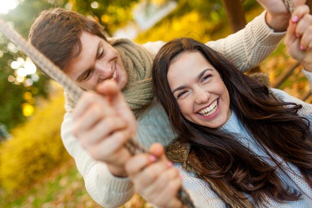 Concepto de amor, relación, familia y personas - sonriente pareja abrazándose en el parque otoño