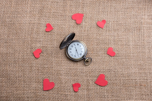 Foto concepto de amor con reloj de bolsillo e iconos en forma de corazón