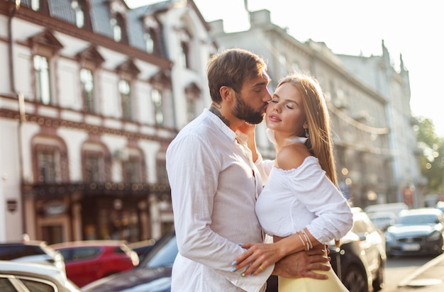 Foto concepto de amor romántico una pareja joven y enamorada se besan en la ciudad al atardecer