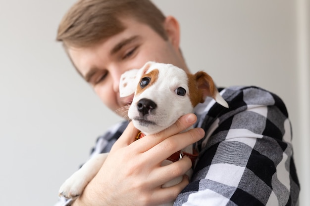 Concepto de animales y mascotas de personas cerca de joven con cachorro de jack russell terrier