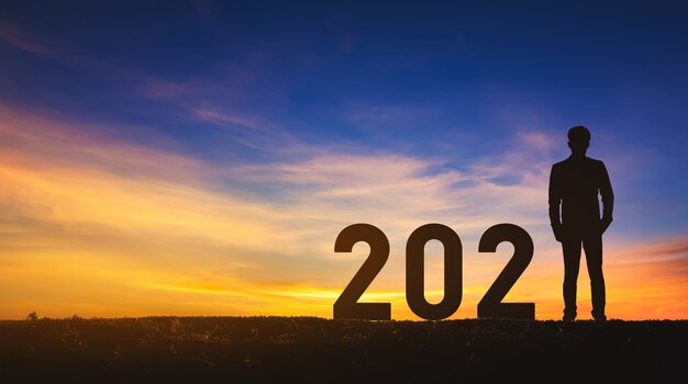 Concepto de año nuevo 2021, hombre de negocios de éxito de silueta con fondo de cielo al atardecer